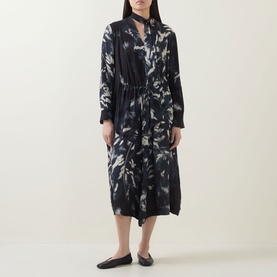 Model wearing HIGH Skive Printed Tie-Front Dress in blue abstract print, midi length with drawstring waist, styled with black flat shoes.