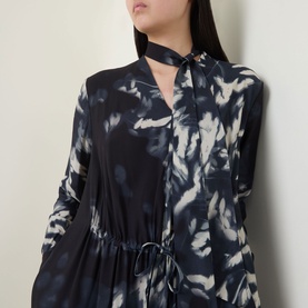 Model wearing HIGH Skive Printed Tie-Front Dress in blue abstract print, featuring scarf neckline, long sleeves and drawstring waist