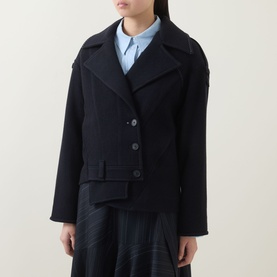 Model wearing HIGH Off Key Jacket in navy, single-breasted with exaggerated notch lapel, shoulder epaulettes and asymmetric hem, styled with blue