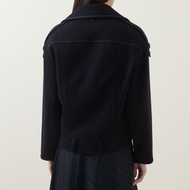 Model wearing HIGH Off Key Jacket in navy, shown from behind, featuring exaggerated notch lapel, shoulder epaulettes and asymmetric hem.