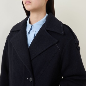Model wearing HIGH Off Key Jacket in navy, featuring exaggerated notch lapel, shoulder epaulettes and button fastening, styled with a light blue