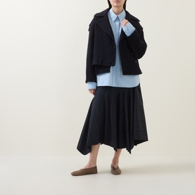 Model wearing HIGH Off Key Jacket in navy with exaggerated lapel and shoulder epaulettes, styled with light blue shirt, black skirt and brown flats.