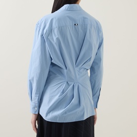 Model wearing HIGH Playful Tie Front Oversized Shirt in light blue, rear view showing twist-pleat back detail and long sleeves