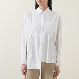 Model wearing HIGH Tumble Down Oversized Shirt in white cotton with pintuck detail, patch pocket, asymmetric hem and long sleeves