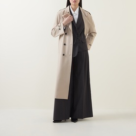 Model wearing HIGH Doff Pleated Pinstripe Trousers in dark grey with wide-leg silhouette, styled with beige trench coat and white shirt.