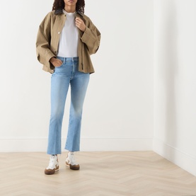 Model wearing Mother Crop Boot jeans in Room Service, styled with a tan oversized jacket, white tee and white trainers.