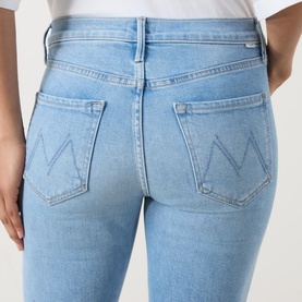 Model wearing Mother Crop Boot jeans in Room Service light blue wash, close-up rear view showing branded double-V stitched back pockets