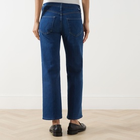 Model wearing Mother Straight Jeans in Pinkies Up mid-blue denim, rear view, styled with black loafers
