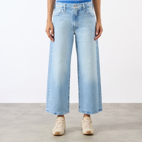 Model wearing Mother The Dodger Ankle Straight Jeans in Fringe Benefits light wash, wide-leg cropped cut, styled with cream trainers