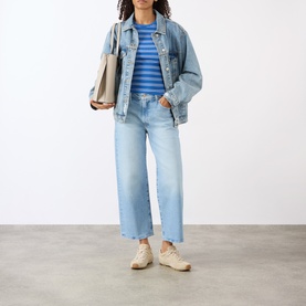 Model wearing Mother The Dodger Ankle Straight Jeans in Fringe Benefits light wash, styled with denim jacket, blue stripe tee and cream trainers