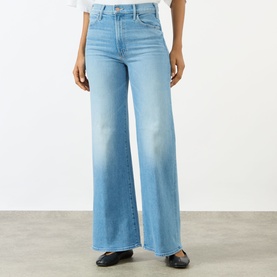 Model wearing Mother The Hustler High-Rise Wide Leg Jeans in Room Service light blue wash, styled with a white top and black flat shoes.