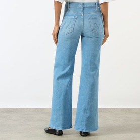 Model wearing Mother The Hustler High-Rise Wide Leg Jeans in Room Service light blue denim, rear view showing wide leg silhouette and back pockets.