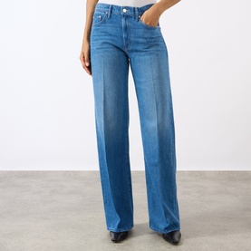Model wearing Mother The Lasso Sneak Wide-Leg Jeans in Breaking New Ground mid-wash blue, wide-leg fit with pressed creases, styled with black heeled