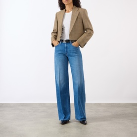 Model wearing Mother The Lasso Sneak Wide-Leg Jeans in Breaking New Ground, mid-wash blue, styled with a cropped blazer and white tee.
