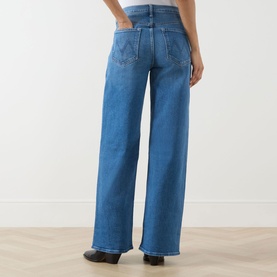 Model wearing Mother Wide Leg jeans in Kissing The Caddy blue denim, rear view, showing high waist, wide leg fit and raw hem detail.