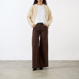 Model wearing Mother Decadent Chocolate wide leg jeans in dark brown, styled with a cream shearling jacket and white tee.