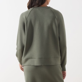 Model wearing Part Two Beetle sweat top, back view, with matching olive green midi skirt