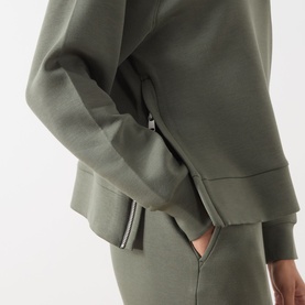Model wearing Part Two Beetle sweat top, close-up of zip cuff detail, styled with matching olive joggers