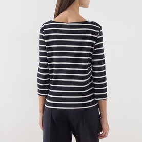 Model wearing Part Two Navy/Eggnog Stripe cotton top, rear view, featuring boat neck and three-quarter length sleeves, paired with navy trousers.