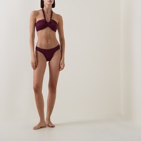 Model wearing Seafolly dark burgundy halterneck bikini top styled with matching bikini briefs
