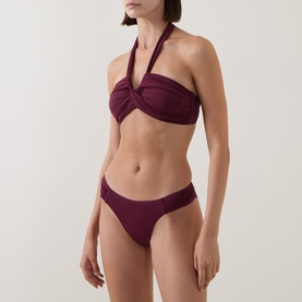 Model wearing Seafolly Dark Burgundy bikini top with twist halterneck detail, styled with matching bikini briefs.
