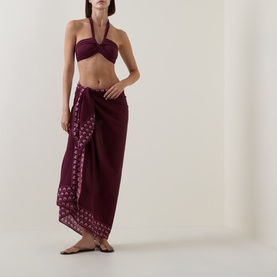 Model wearing Seafolly Dark Burgundy bikini top, styled with a matching burgundy embroidered sarong and flat sandals.