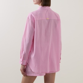 Model wearing Seafolly Light Pop Pink cotton striped oversized shirt cover-up, rear view, with coordinating pink shorts