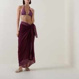 Model wearing Seafolly Dark Burgundy cotton sarong, tied at waist, styled with matching triangle bikini top and flat sandals.