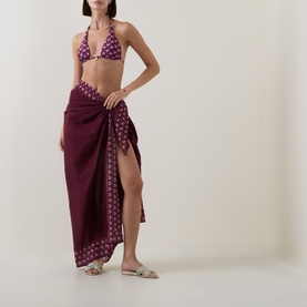 Model wearing Seafolly Dark Burgundy bikini top with floral print, styled with matching sarong and nude flat sandals.