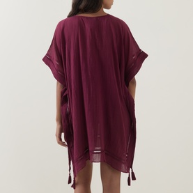 Model wearing Seafolly dark burgundy cotton cover-up, back view, short sleeves, tassel hem ties, relaxed kaftan silhouette