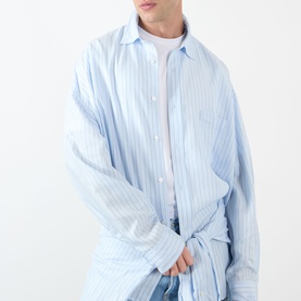 Model wearing Acne Stripe Logo Shirt in blue, oversized fit with classic collar, long sleeves, and vertical stripe pattern.