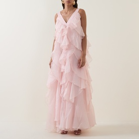 Model wearing Aje Athena Ruffle Gown in Tea Blossom; sleeveless maxi dress with V-neckline and tiered ruffles throughout