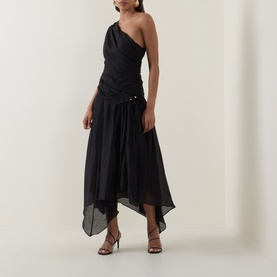 Model wearing black one-shoulder midi dress with ruched bodice, button detail, and asymmetric handkerchief hem, styled with strappy heels