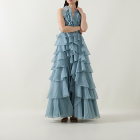 Model wearing Aje Cleo Ruffle Gown in Duck Egg, featuring tiered ruffle skirt, halter neckline and sleeveless silhouette