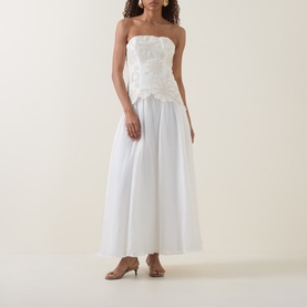 Model wearing Aje Gia Embroidered Off-The-Shoulder Gown in ivory, featuring floral embroidered bodice and full midi skirt, styled with nude kitten