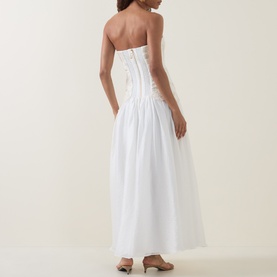 Model wearing Aje Gia Embroidered Off-The-Shoulder Gown in ivory, showing rear view with back zipper and full midi skirt