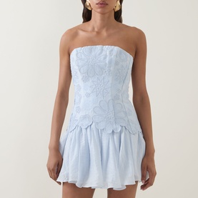 Model wearing Aje Gia Embroidered Mini Dress in Pastel Blue; strapless with mandala embroidery, fitted bodice and peplum skirt