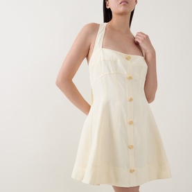 Model wearing Aje Monroe Halter Mini Dress in Butter, featuring halter neck, front button fastening and A-line silhouette