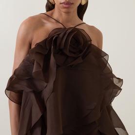 Model wearing Aje Pandorea Ruffle Mini Dress in Carob, featuring halter neckline, oversized 3D rose appliqu&eacute; and layered organza ruffles