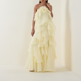 Model wearing Aje Pandorea Ruffle Dress in Butter, halter neck maxi with layered ruffles and voluminous silhouette