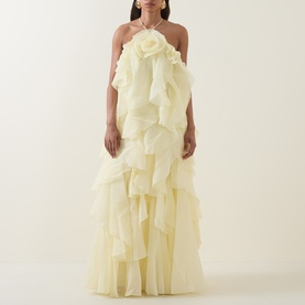 Model wearing Aje Pandorea Ruffle Dress in butter, halterneck maxi with layered organza ruffles and voluminous silhouette, gold chain necklace