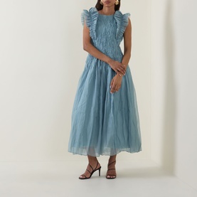 Model wearing Aje Mathilde Dress in Duck Egg; tulle midi with ruffle shoulders, pintuck detail and gathered bodice. Styled with black heeled sandals.