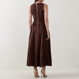 Model wearing Aje Dark Chocolate linen-viscose midi dress, sleeveless with pintuck bodice detail and full skirt, back view.