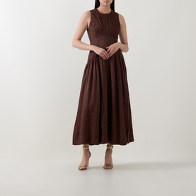 Model wearing Aje Dark Chocolate linen-viscose midi dress, sleeveless with gathered skirt, styled with nude heeled sandals.
