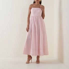 Model wearing Aje Rosie Dress in Tea Blossom; straight neckline, shoulder straps, gathered midi skirt. Styled with nude heeled sandals.