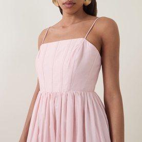 Model wearing Aje Rosie Dress in Tea Blossom, featuring straight neckline, thin shoulder straps, angled panelled bodice with topstitching and full