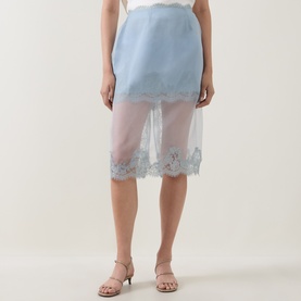 Model wearing Aje Ophelia Lace-Trim Layered Skirt in Duck Egg, semi-sheer overlay with lace hem, styled with strappy flat sandals.