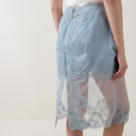 Model wearing Aje Ophelia Lace-Trim Layered Skirt in Duck Egg; semi-sheer silk overlay with floral lace trim detailing visible at hem.