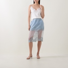Model wearing Aje Ophelia Lace-Trim Layered Skirt in Duck Egg, semi-sheer overlay with lace trim, styled with white lace cami and nude heels.