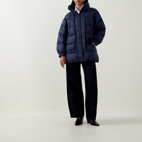 Model wearing HIGH dark blue quilted puffer coat with patch pockets, styled with wide-leg trousers and black loafers.